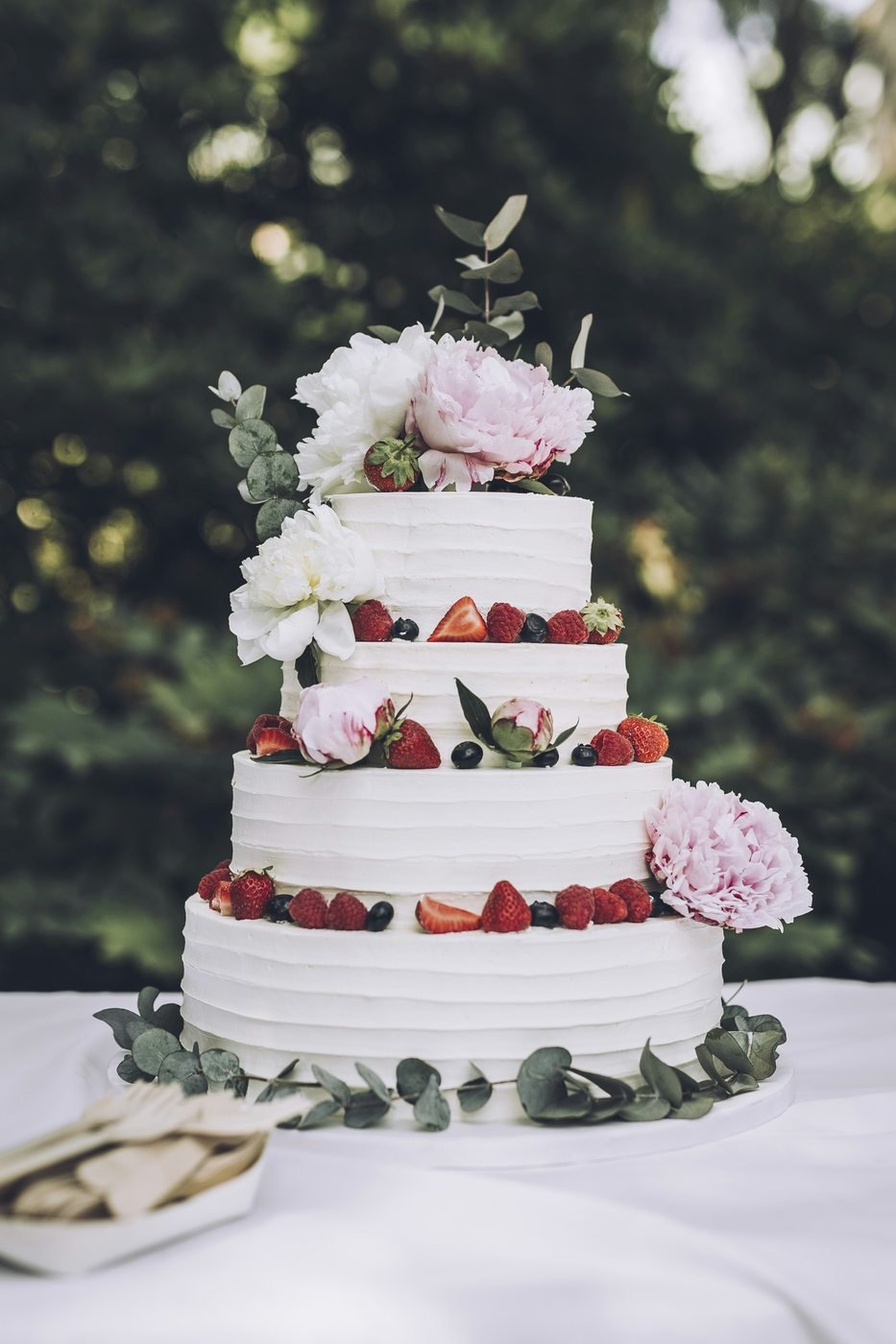 White wedding cake with fresh strawberries and flowers