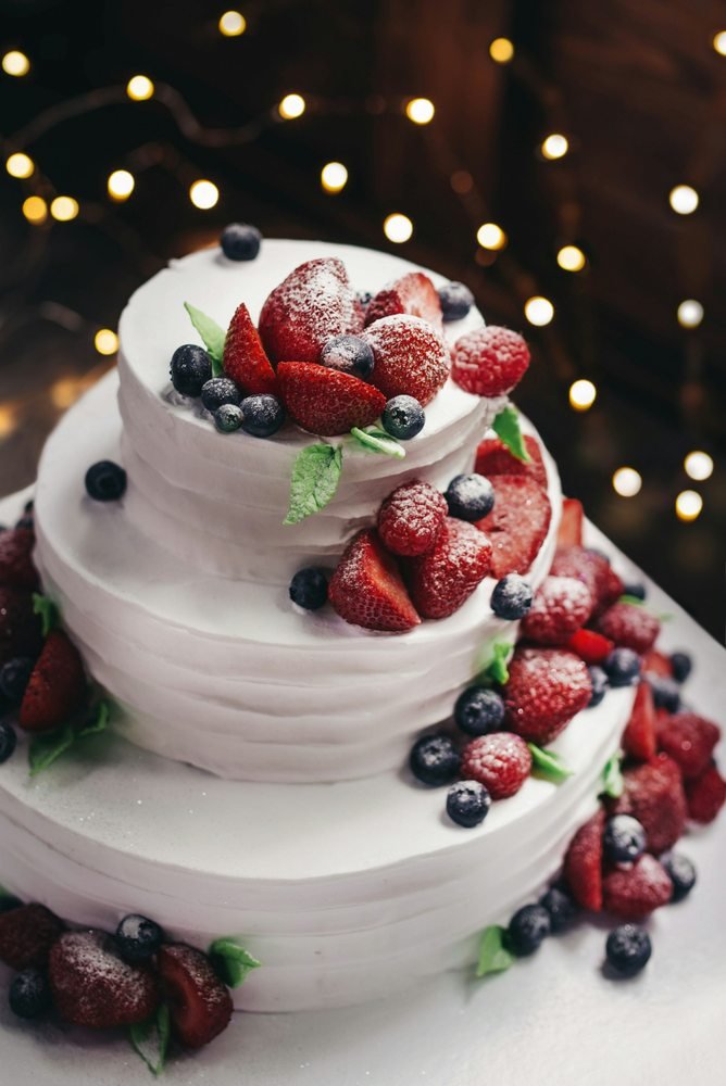 Three-tier vanilla cake with blueberries and strawberries